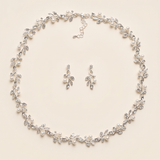 A necklace and earrings set with a delicate leaf-like design and sparkling crystal elements.