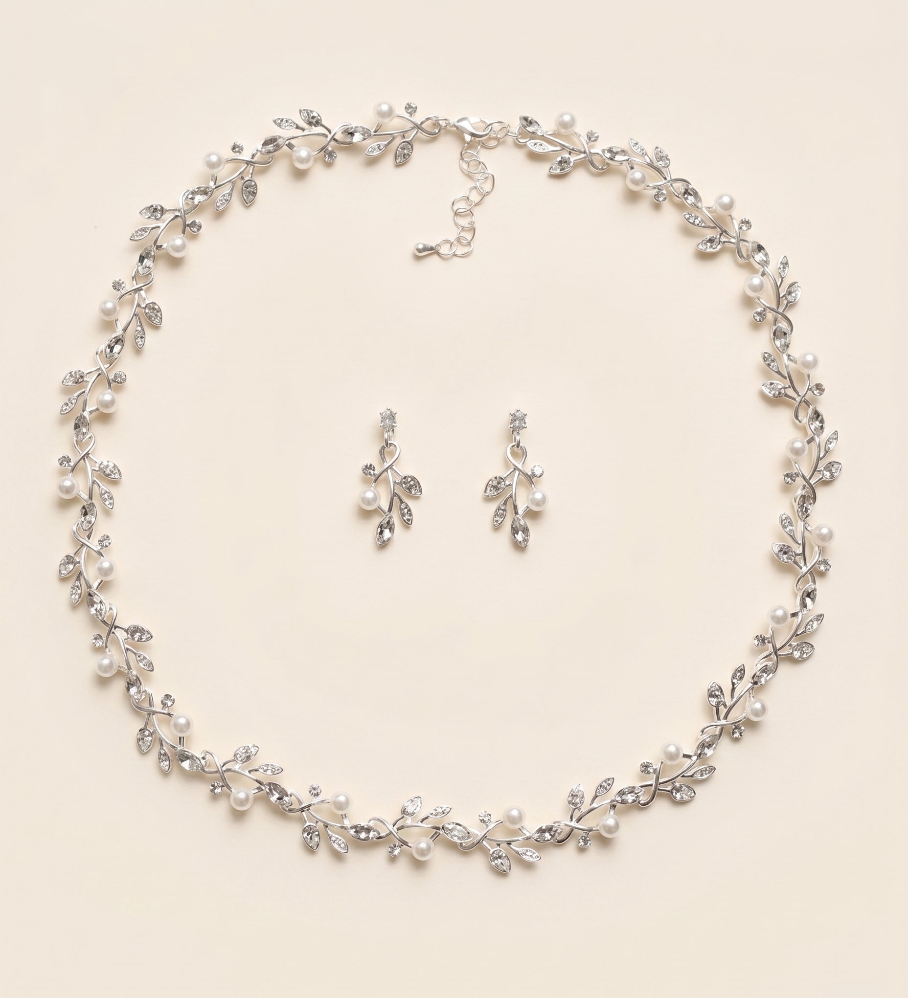 A necklace and earrings set with a delicate leaf-like design and sparkling crystal elements.