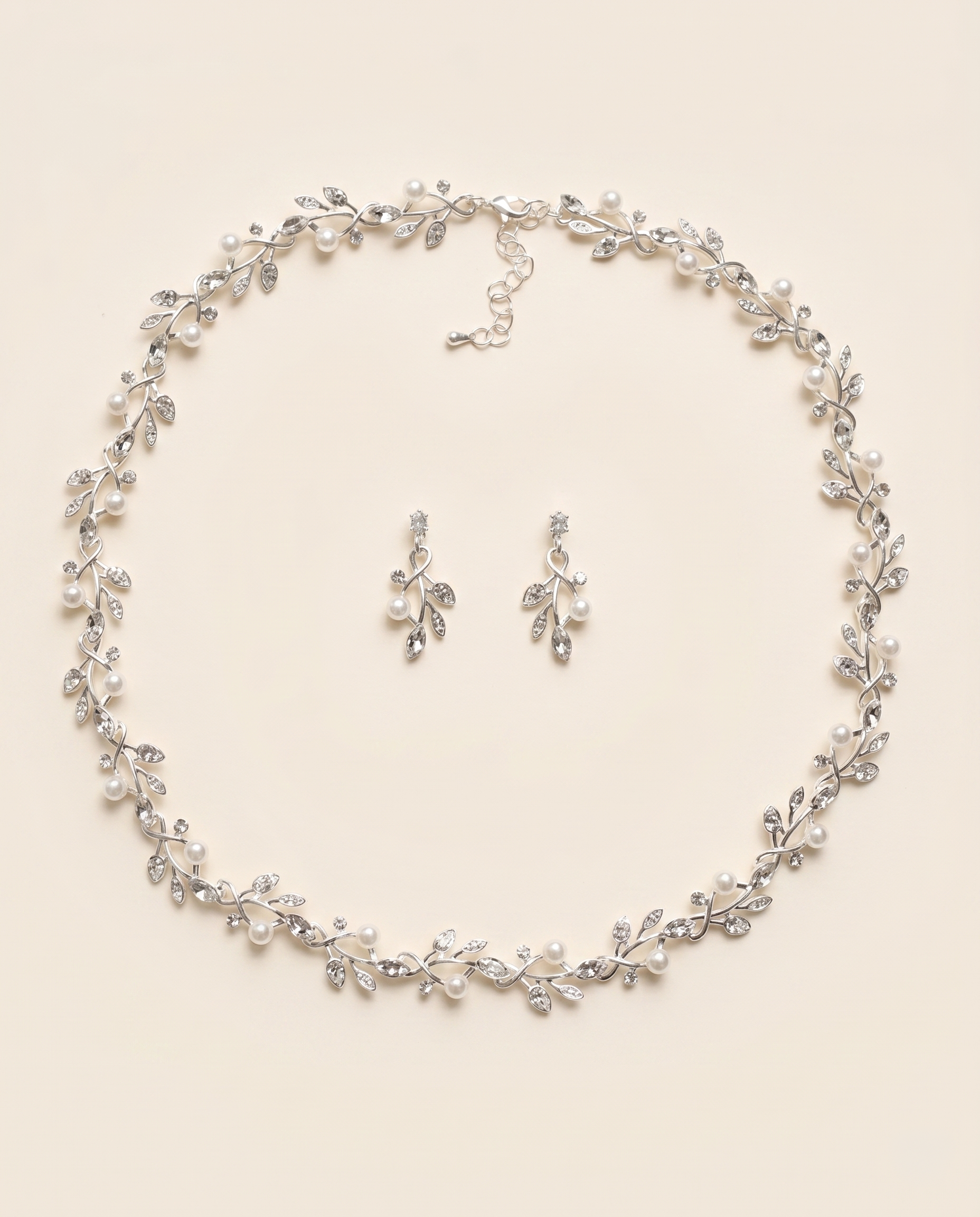 A necklace and earrings set with a delicate leaf-like design and sparkling crystal elements.