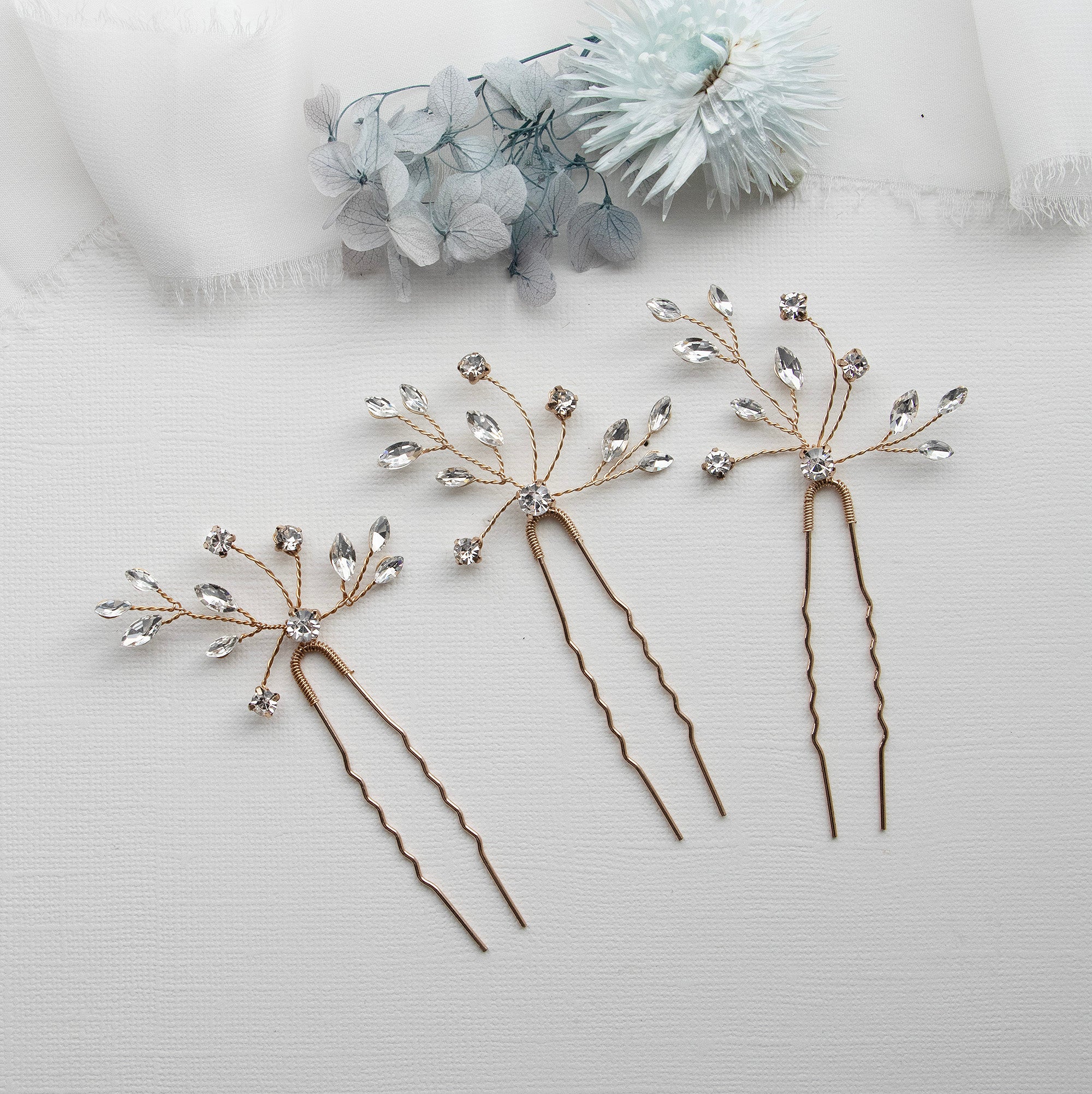 three different types of hair pins on a white surface