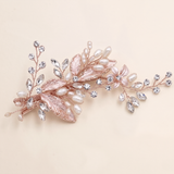 A decorative hair clip adorned with pearls, crystals, and leaves.