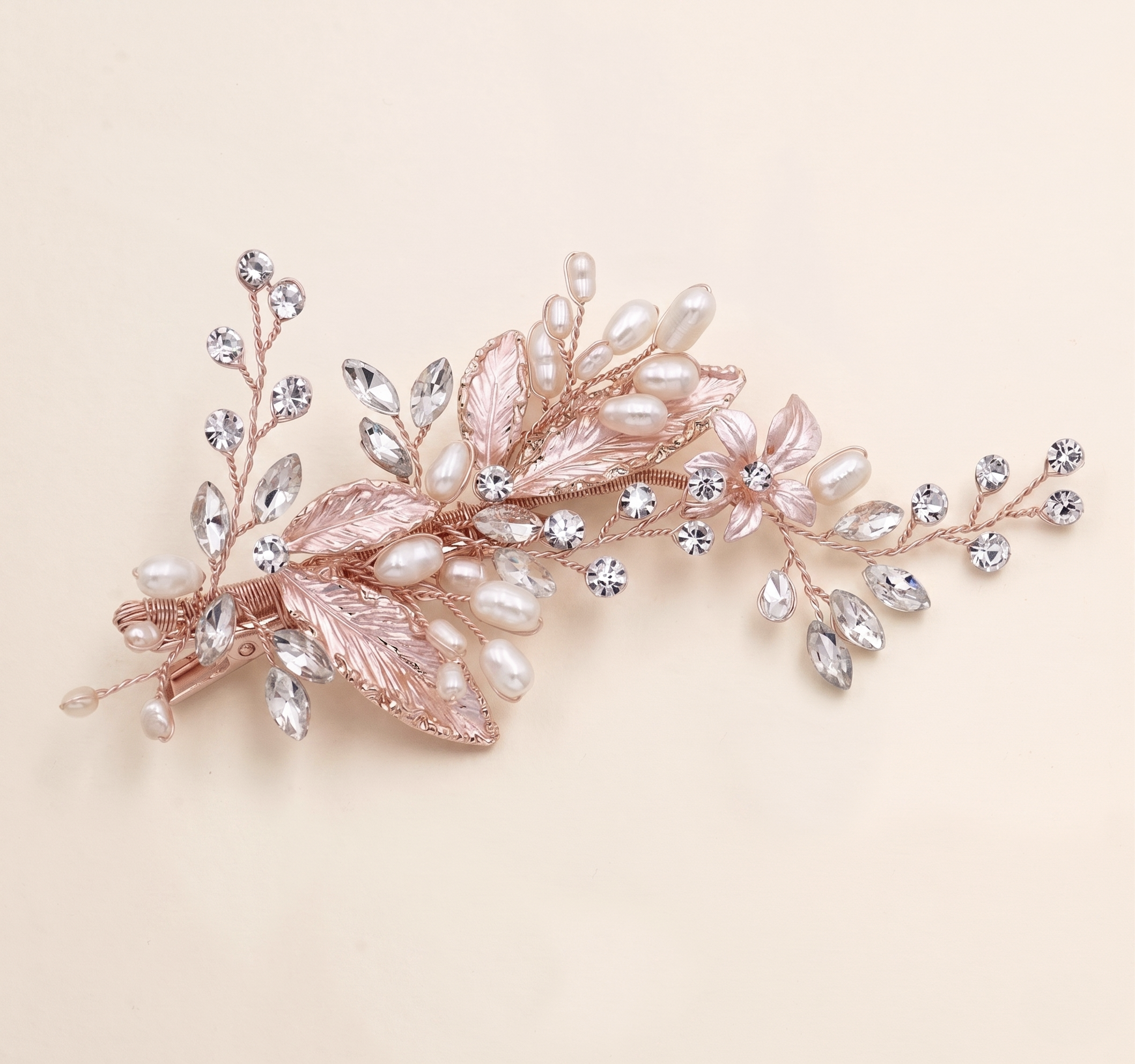 A decorative hair clip adorned with pearls, crystals, and leaves.