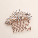 A decorative hair accessory with a gold-colored metal frame and a floral design, featuring clear gemstones and pearls.