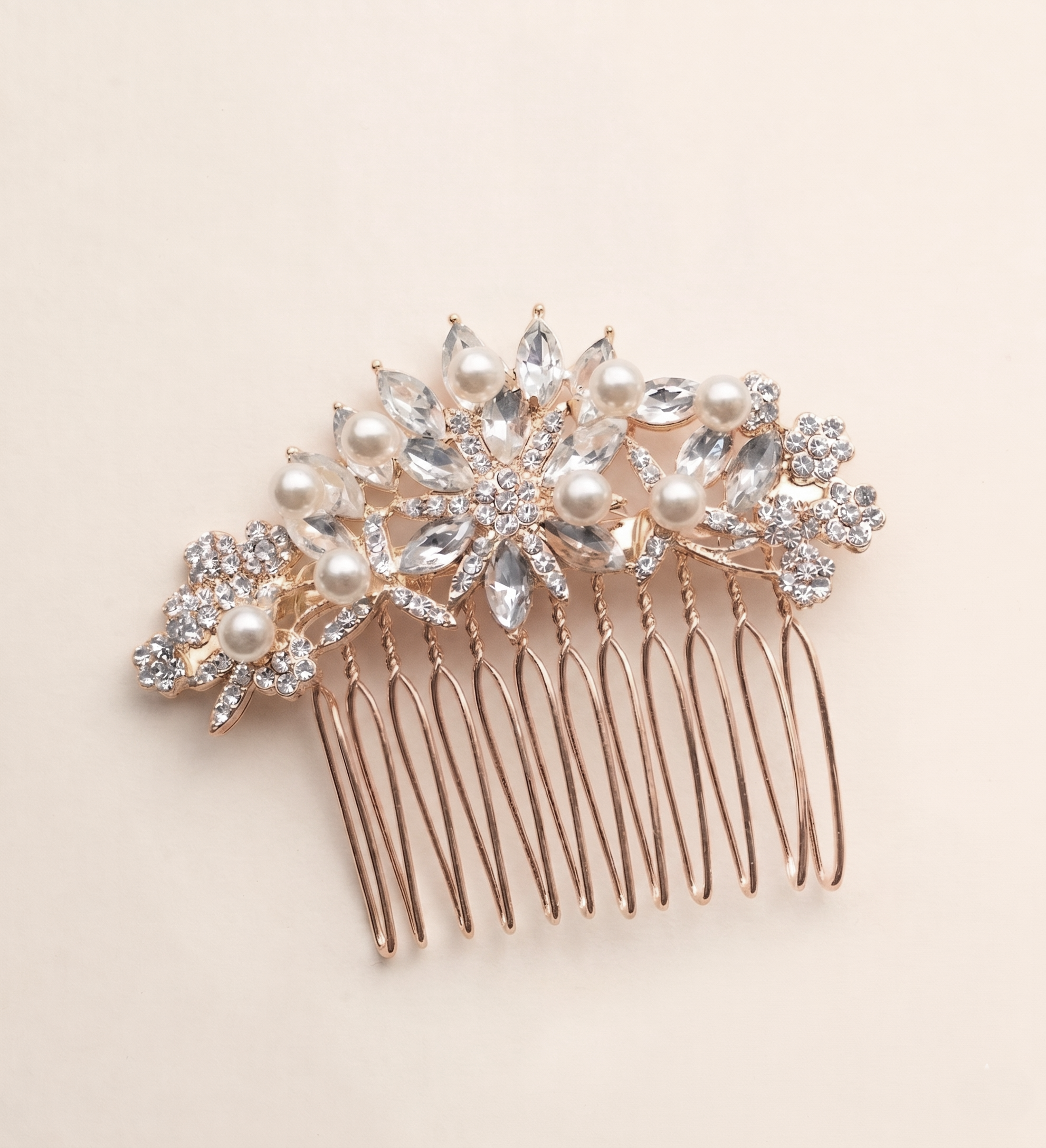 A decorative hair accessory with a gold-colored metal frame and a floral design, featuring clear gemstones and pearls.
