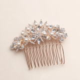A decorative hair accessory with a gold-colored metal frame and a floral design, featuring clear gemstones and pearls.