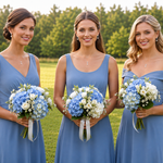 Three women in blue dresses holding bouquets of white and blue flowers stand together in a grassy field.