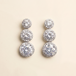 A pair of elegant diamond earrings with multiple tiers of round stones set in a halo-like design.