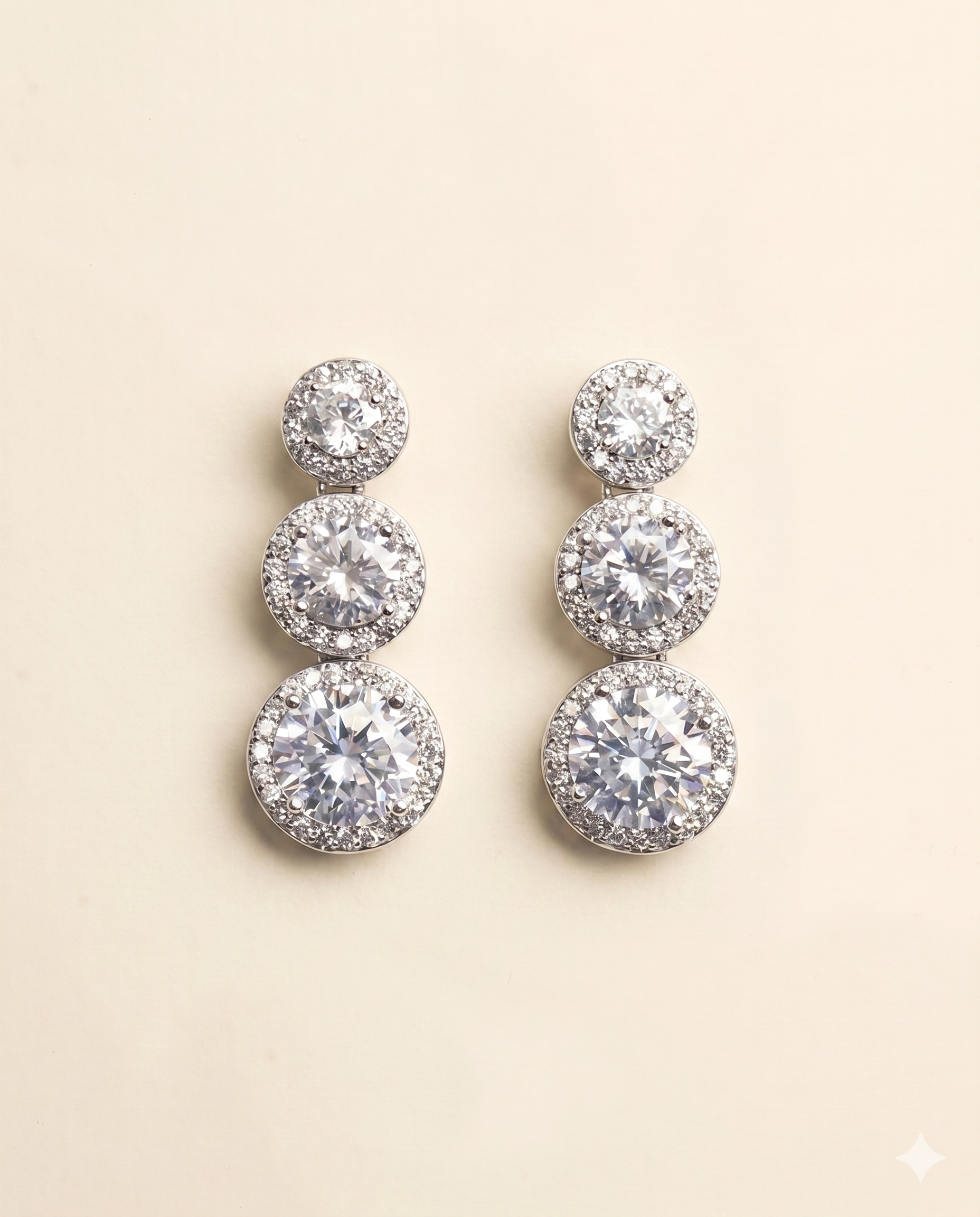 A pair of elegant diamond earrings with multiple tiers of round stones set in a halo-like design.