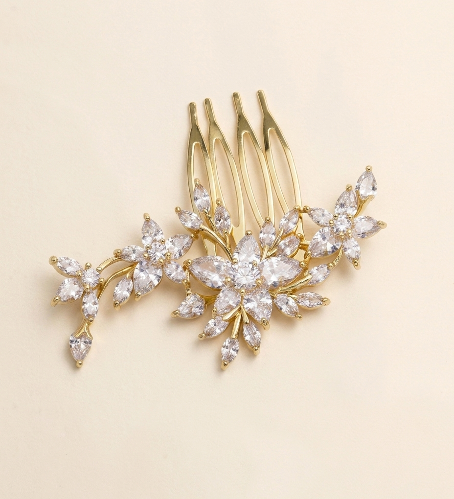 A gold-colored hair accessory with a floral design, featuring multiple small, clear gemstones or crystals arranged in a decorative pattern.