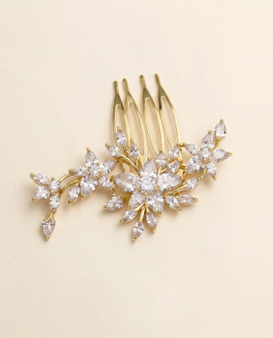 A gold-colored hair accessory with a floral design, featuring multiple small, clear gemstones or crystals arranged in a decorative pattern.