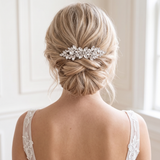 the back view of a woman's blonde hair styled in a bun, with a decorative hair accessory, likely a hair clip or hairpiece, placed in the center of her hair.