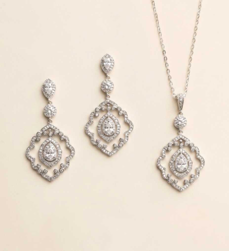 a set of elegant jewelry pieces, including earrings and a necklace, both adorned with sparkling diamonds.