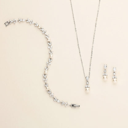 a necklace, earrings, and bracelet on a white surface