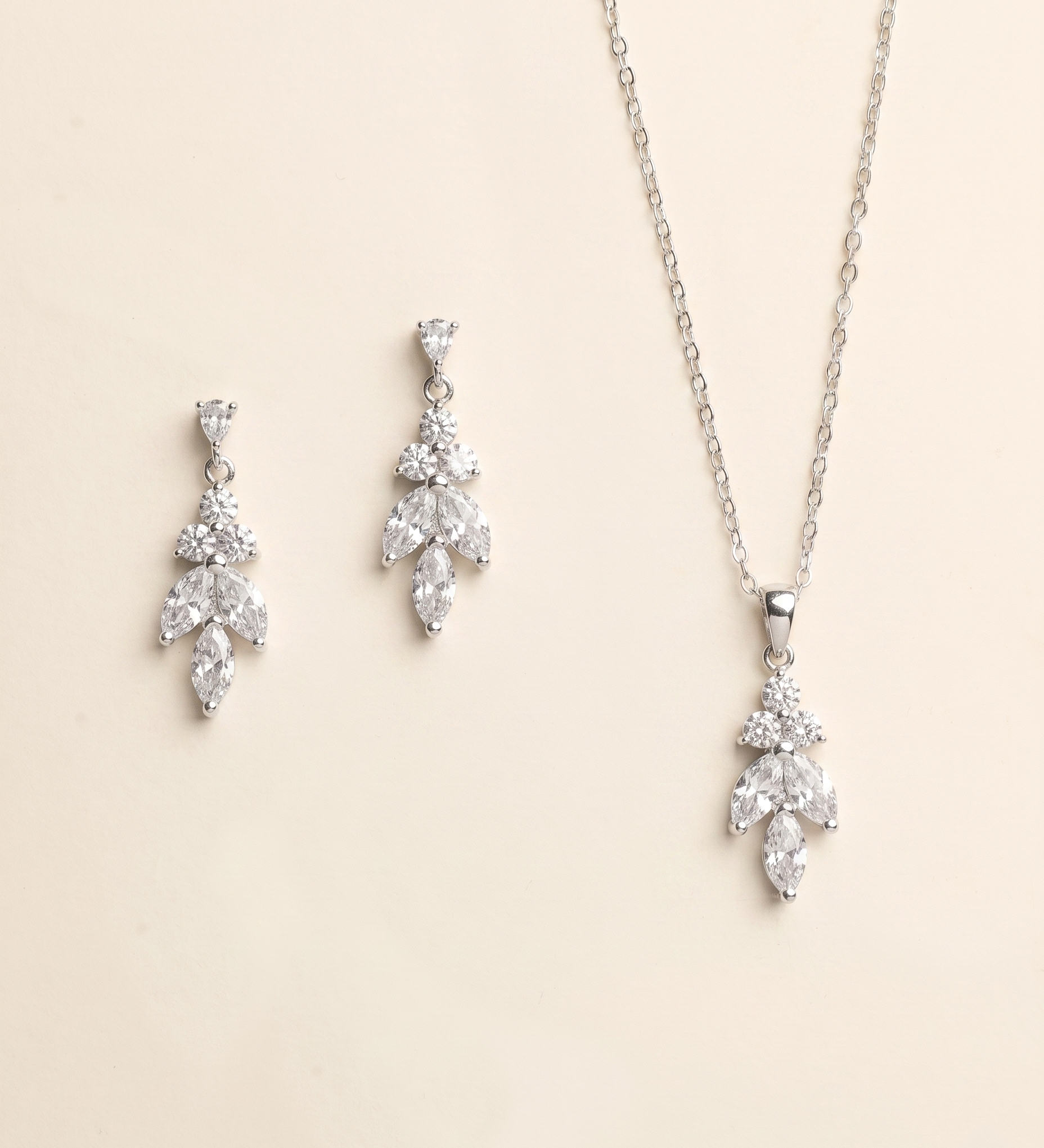 a necklace and earrings set against a light beige background.