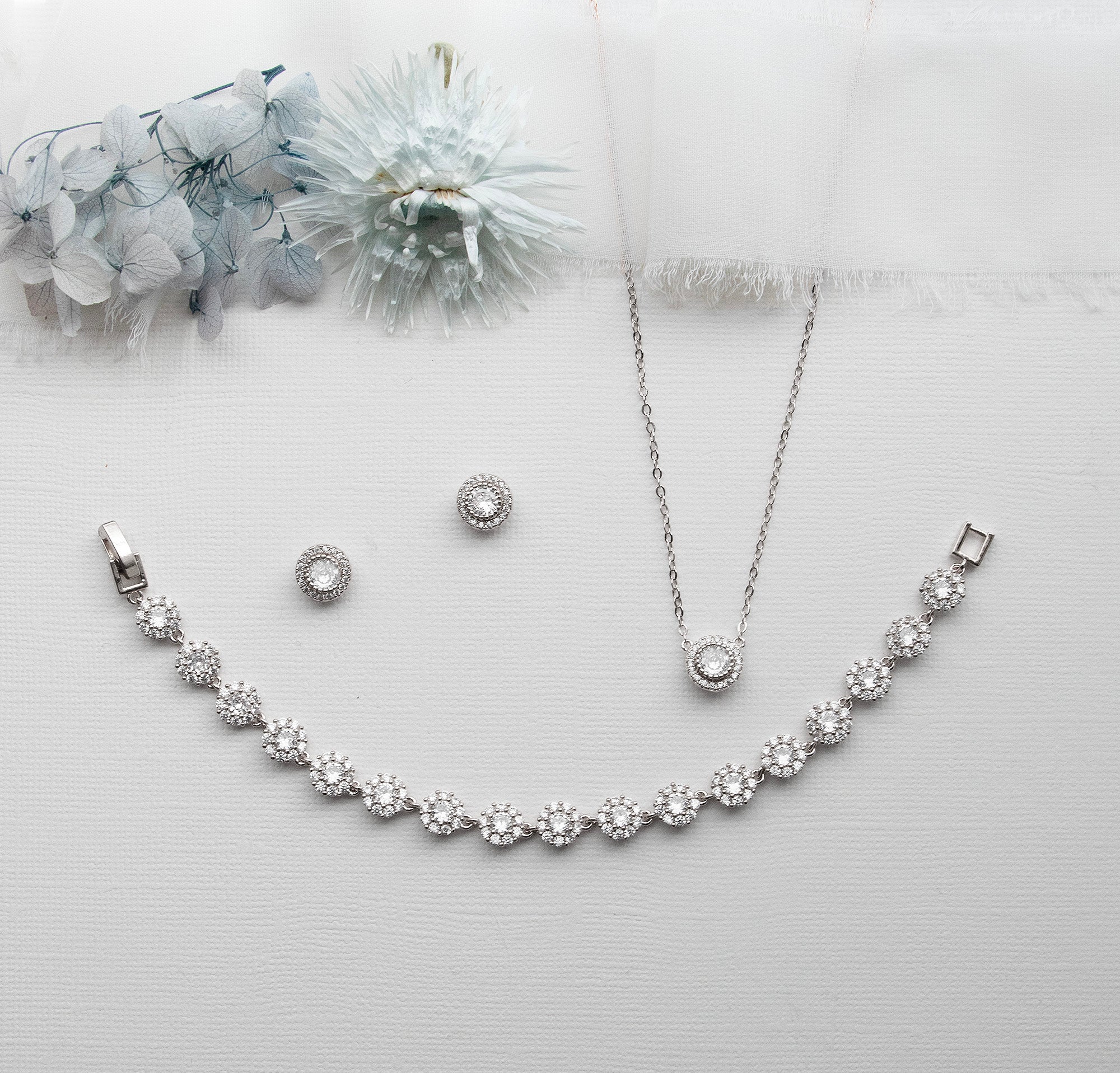 a necklace, earrings, and bracelet on a white surface