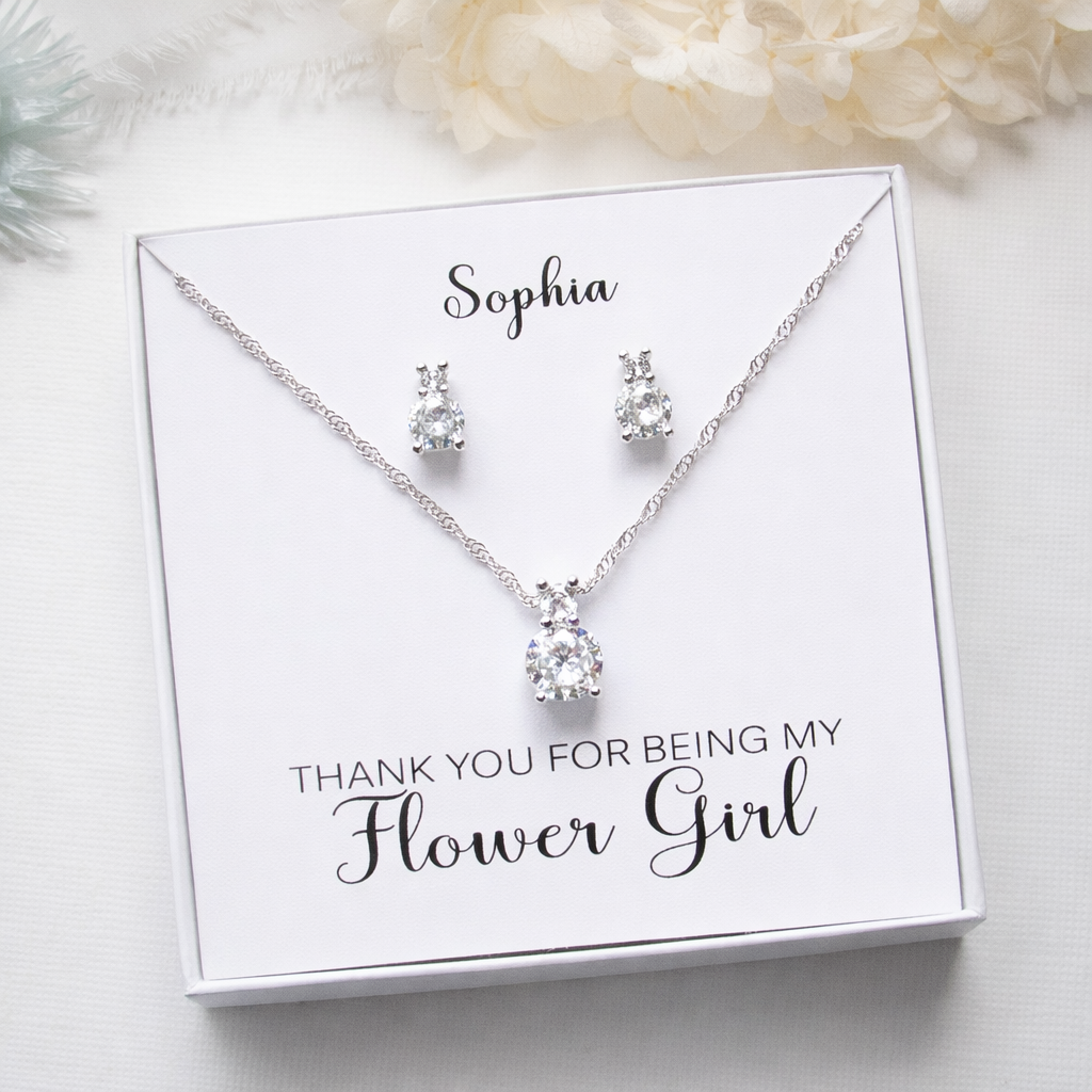 A necklace and earrings set presented in a white box with a personalized message.