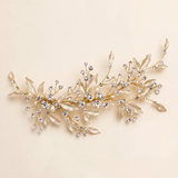 A decorative piece of jewelry with a branch-like design, adorned with small, clear gemstones or crystals.