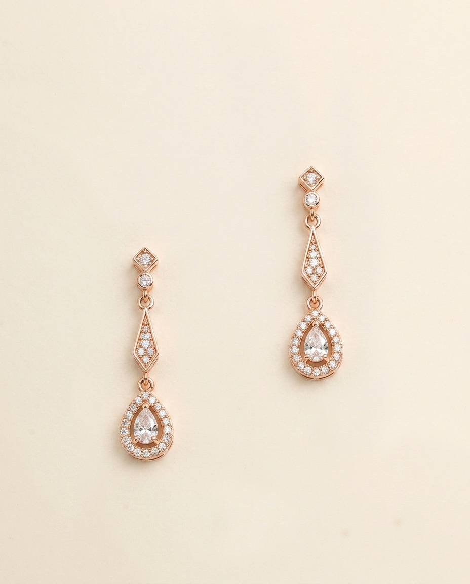 a pair of elegant gold earrings with small diamonds hanging from the ends.