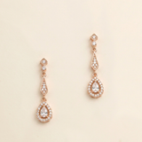 a pair of elegant gold earrings with small diamonds hanging from the ends.