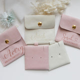 a collection of pink and white bridesmaid bags, each with a personalized name printed on it.