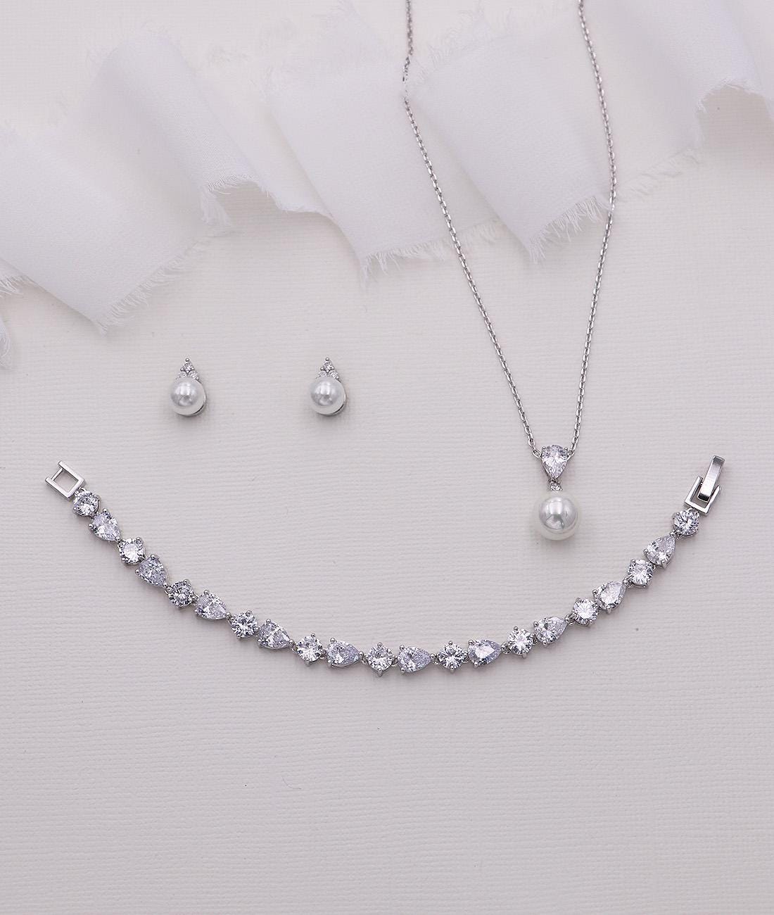 a necklace, earrings, and bracelet on a white background