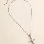 A silver cross necklace with a pendant of pearls and diamonds.