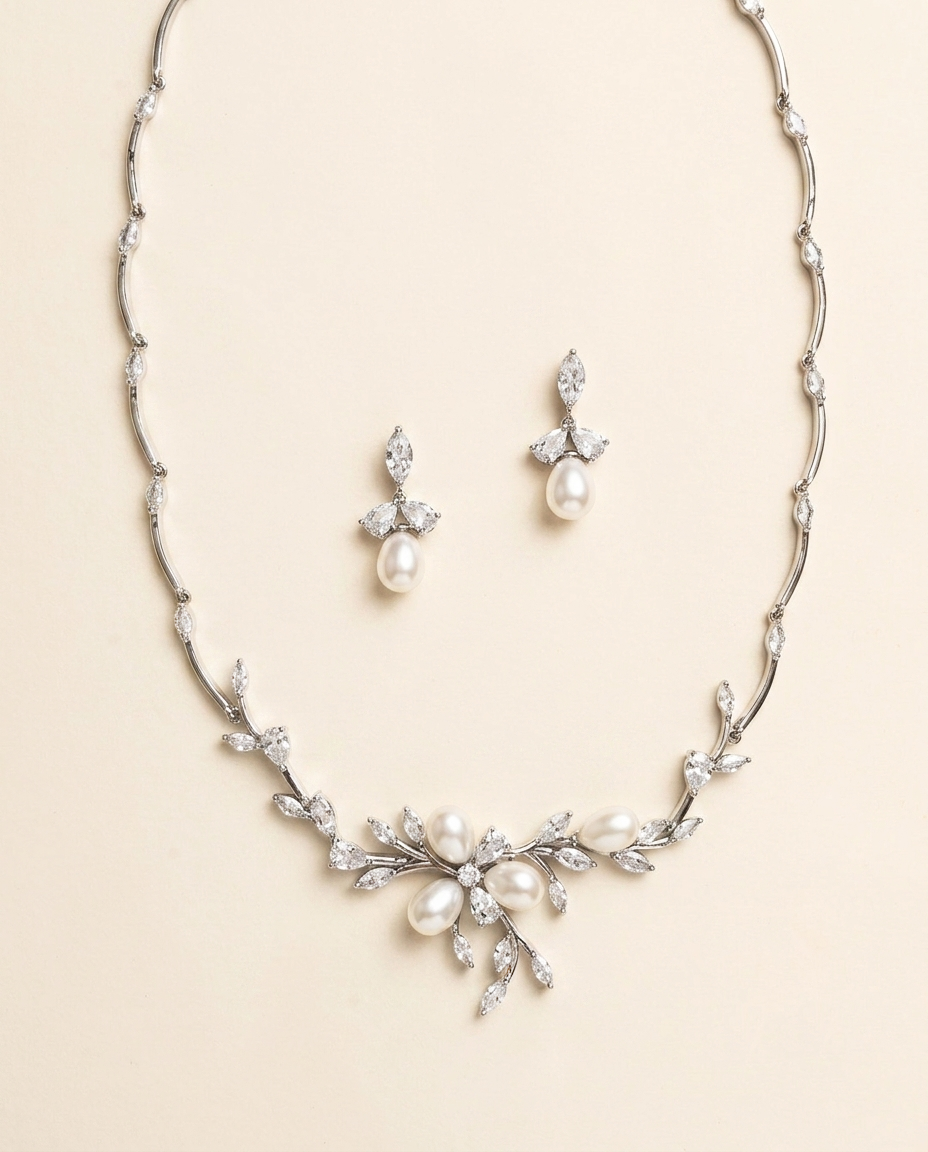 A necklace and earrings set made of silver and white diamonds, featuring a floral design with pearls and diamonds.