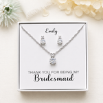 A necklace and earrings set presented in a white box, with a personalized message on the box.