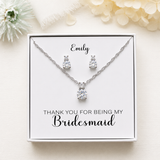 A necklace and earrings set presented in a white box, with a personalized message on the box.