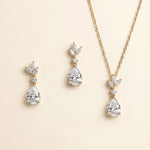 A necklace and earrings set with a gold chain and pendant adorned with small diamonds.
