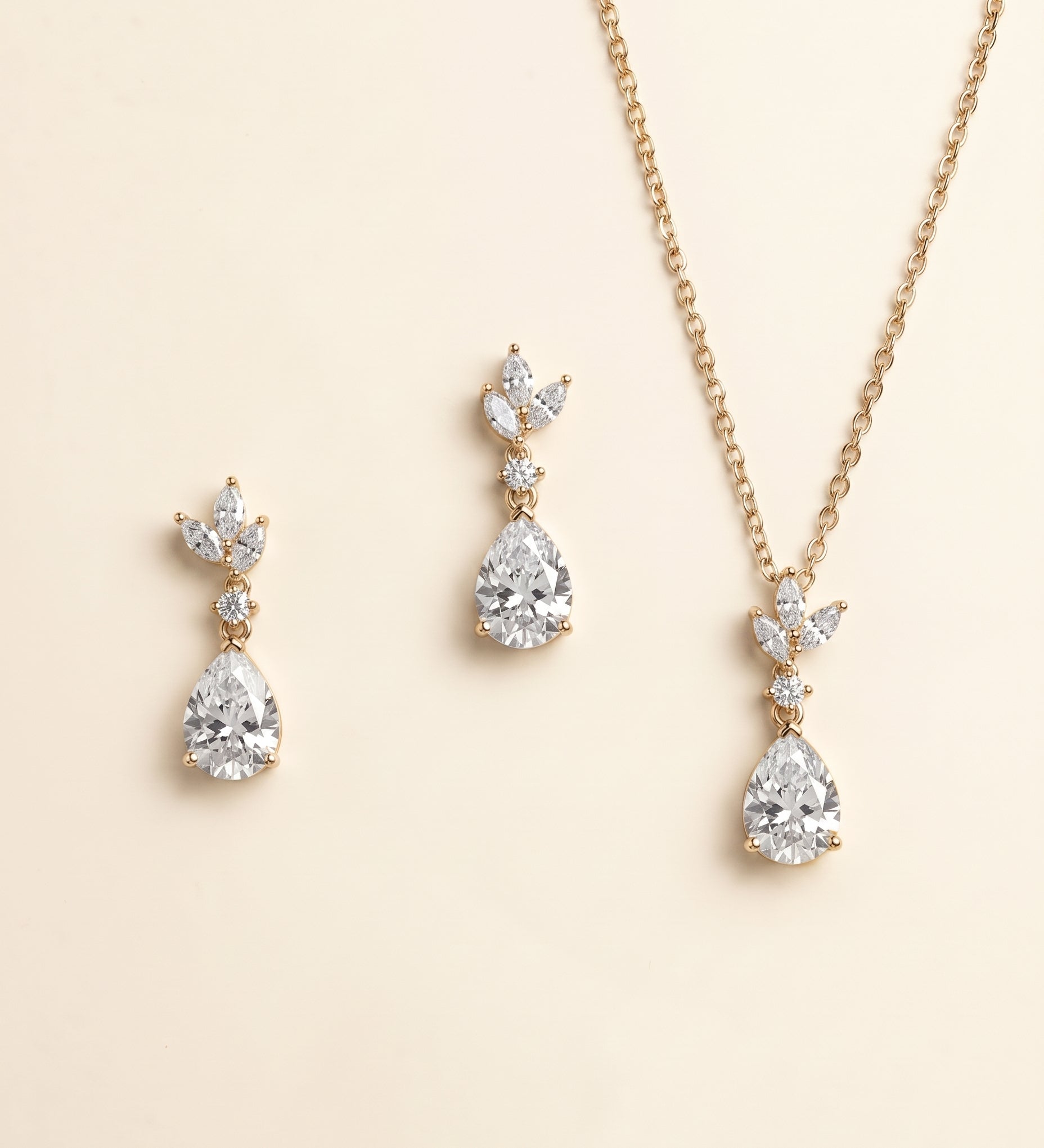 A necklace and earrings set with a gold chain and pendant adorned with small diamonds.