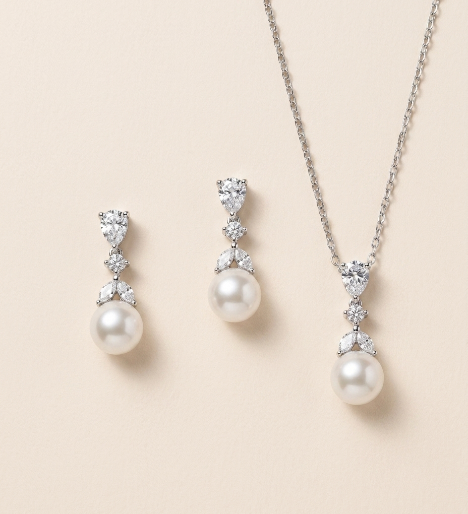 A necklace and earrings set with white pearls and diamonds.
