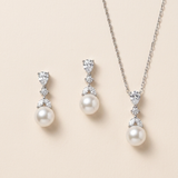 A necklace and earrings set with white pearls and diamonds.