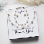A gift box containing a necklace and bracelet with pearls, accompanied by a personalized message that says "Thank you for being my Flower Girl".