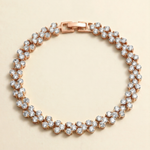 A delicate gold-toned bracelet adorned with numerous small, clear diamonds arranged in a circular pattern.