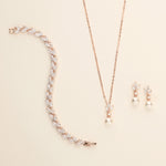 a necklace, bracelet, and earring set on a white surface