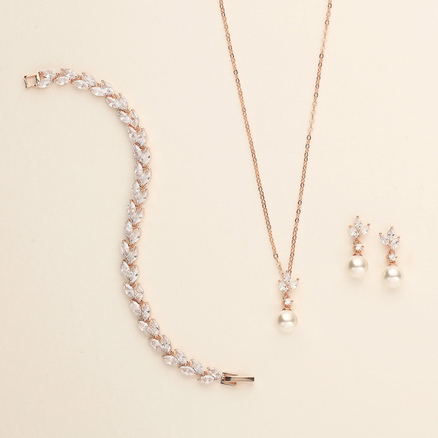 a necklace, bracelet, and earring set on a white surface