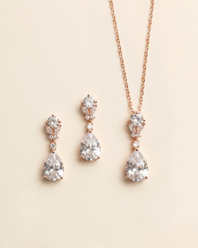 A necklace and earrings set with a pendant and dangling earrings, all featuring large, clear gemstones.