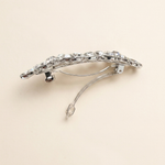A silver hair clip adorned with sparkling rhinestones.