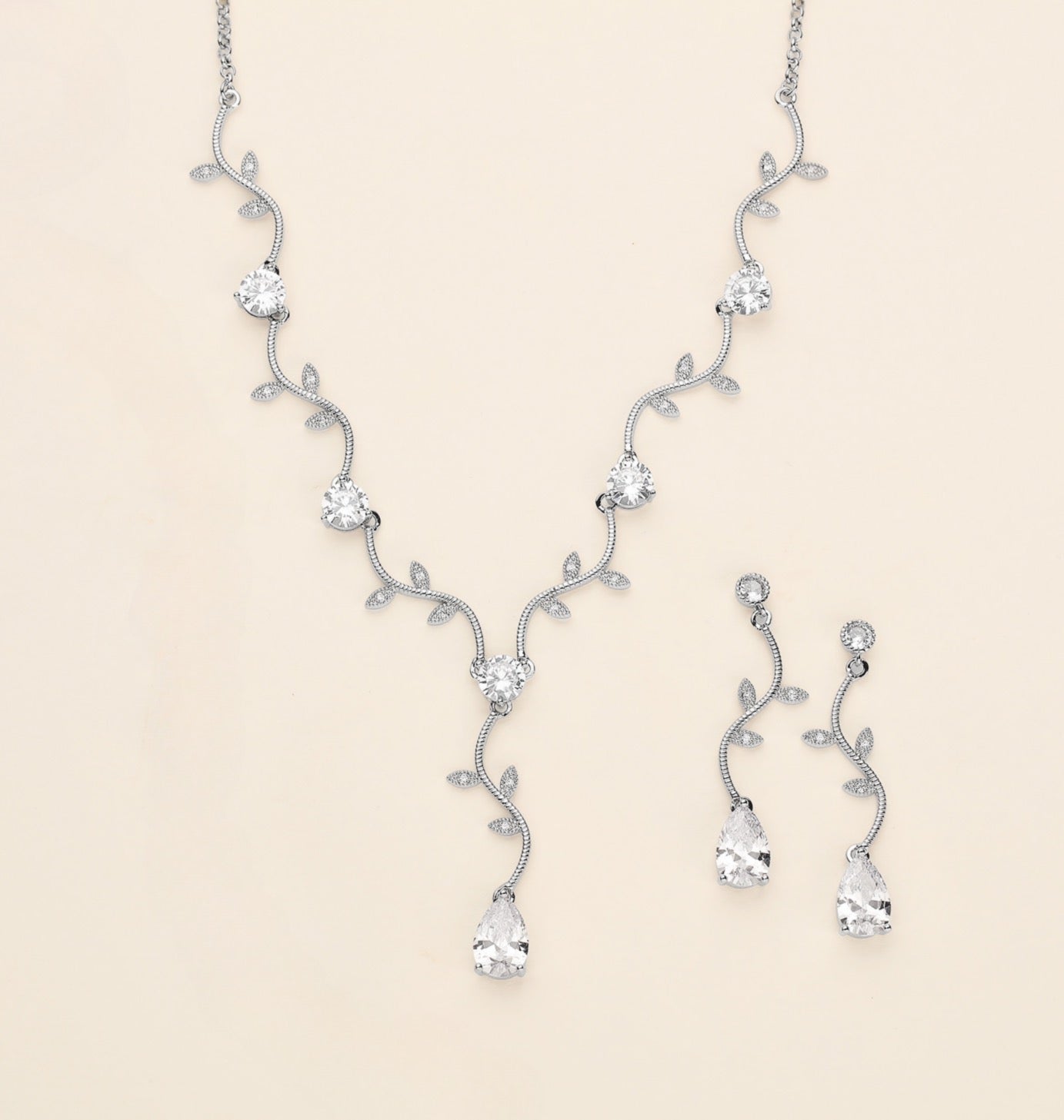 a collection of elegant jewelry pieces, including a necklace, earrings, and a bracelet, all adorned with sparkling diamonds and leaves.
