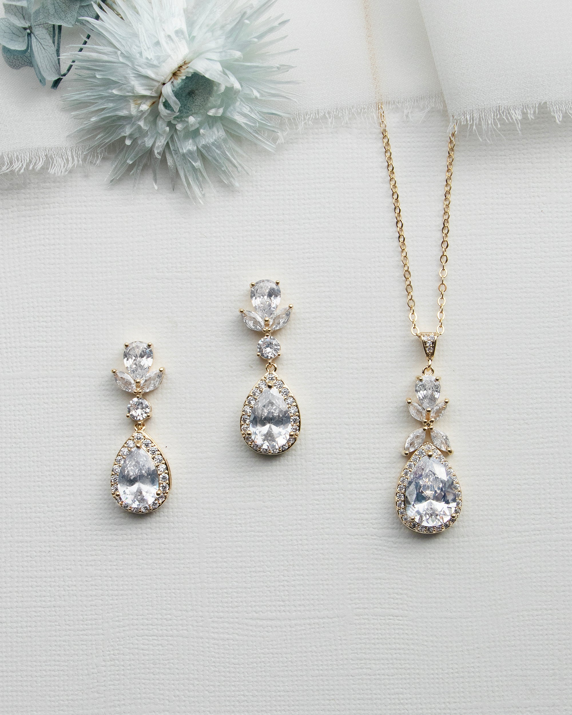 three pieces of jewelry on a white surface