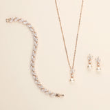 a necklace, bracelet, and earring set on a white surface