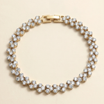 A gold-colored bracelet adorned with numerous small, clear diamonds arranged in a circular pattern.