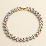 A gold-colored bracelet adorned with numerous small, clear diamonds arranged in a circular pattern.