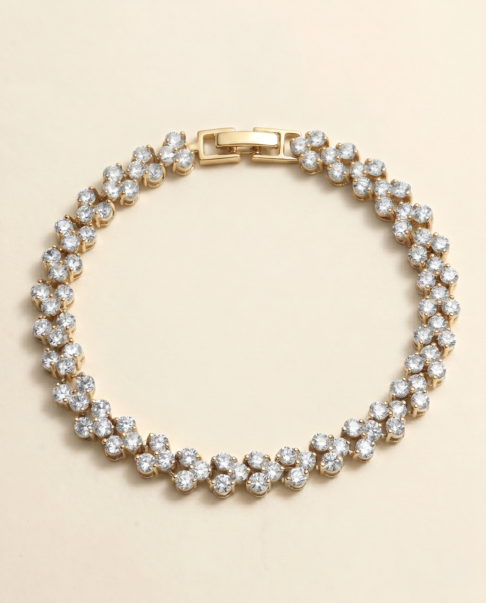 A gold-colored bracelet adorned with numerous small, clear diamonds arranged in a circular pattern.