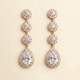 A pair of elegant gold earrings with a large, clear gemstone at the center, surrounded by smaller diamonds.