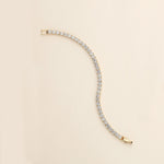a gold and diamond bracelet on a white background