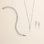 a necklace, earrings, and bracelet on a white surface