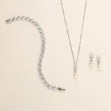a necklace, earrings, and bracelet on a white surface