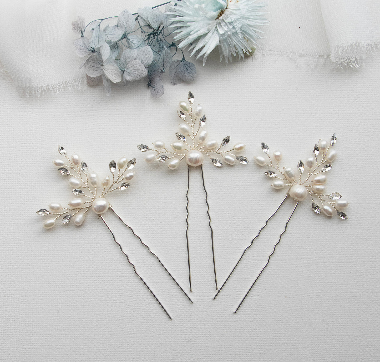 three hair pins with pearls and leaves on them